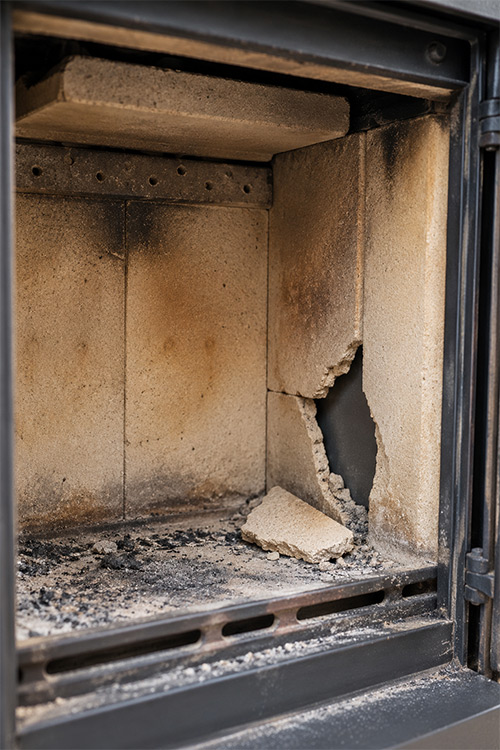 Abgefallener Schamottstein mit sichtbarer Beschädigung der Feuerraumauskleidung